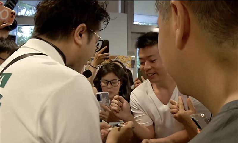 有曾與沈伯洋同校的民眾拿學生證請沈伯洋簽名。(圖/翻攝畫面)