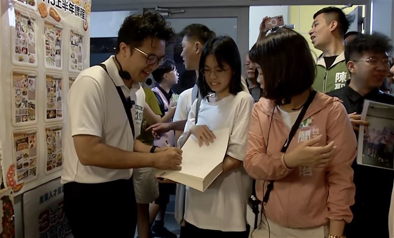 有民眾拿書本、棒球請沈伯洋簽名。(圖/翻攝畫面)