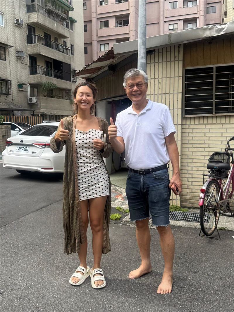薔爸穿著白色POLO衫搭牛仔短褲,直接赤腳站在街頭與女兒比讚。(圖/翻攝自薔薔FB)