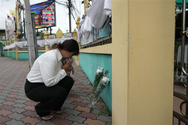 槍擊案發生後一名女子在學校前獻花祈福。（圖／美聯社／達志影像）