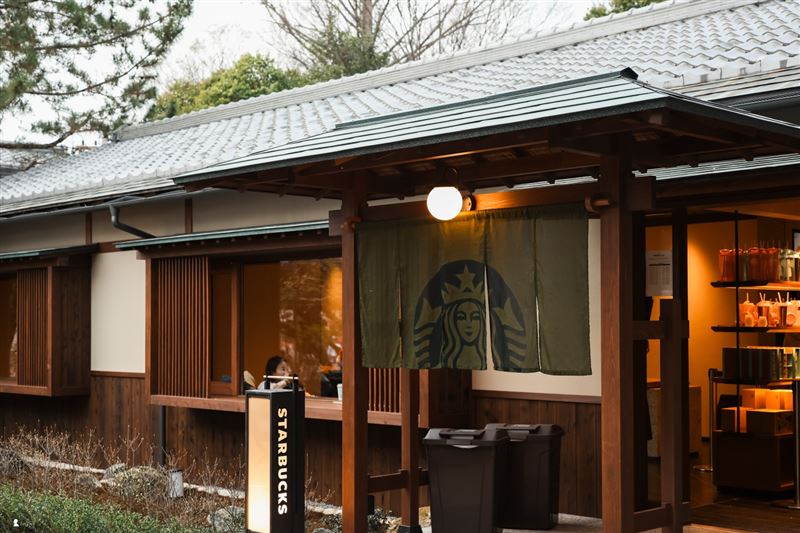 木造家屋懸掛著深綠色暖簾,星巴克「咖啡茶屋」安靜融入円山公園的百年林園景色之中