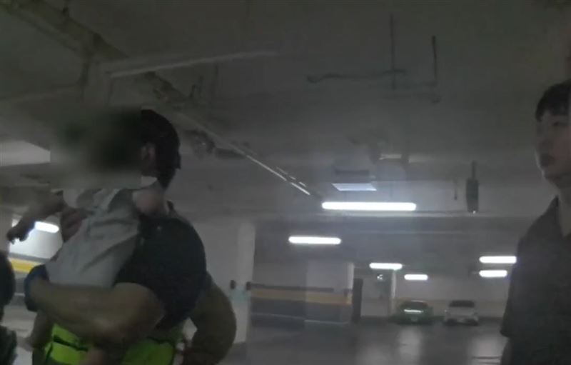 男嬰受困密閉車內長達60分,全程沒有哭鬧,淡定睜著大大萌眼看著警消人員。(圖/翻攝畫面)
