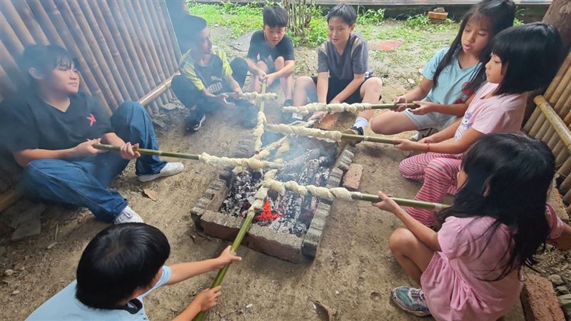 在克難的環境中升火自炊,學生親手翻烤肉品、將麵糰纏繞於竹枝上製成傳統「蛇麵」。圖:教育局提供。(圖/桃園電子報提供)