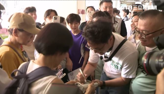 沈伯洋東門市場掃街,替民眾簽名。(圖/翻攝畫面)