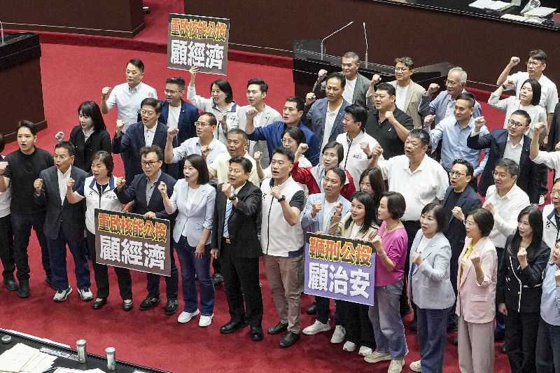 立法院會14日處理藍白兩黨團提出的公投提案,國民黨立委齊聚議場,高舉「重啟核能公投、顧經濟」及「鞭刑公投、顧治安」手板,高呼口號表達支持立場。(圖/中央社)