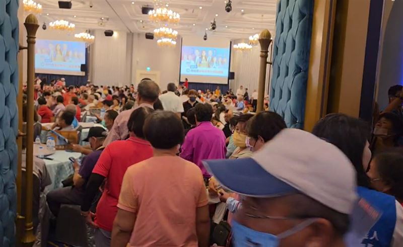 急著搶領餐盒的支持者,在志工勸說下,重新回到座位聽演講。(圖/翻攝畫面)