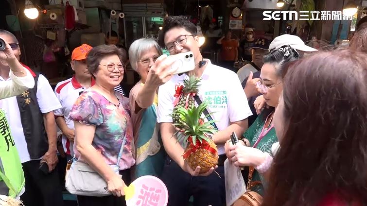 沈伯洋中坡福德市場拜票,婆媽送上鳳梨祝福選情旺旺旺。(圖/翻攝畫面)
