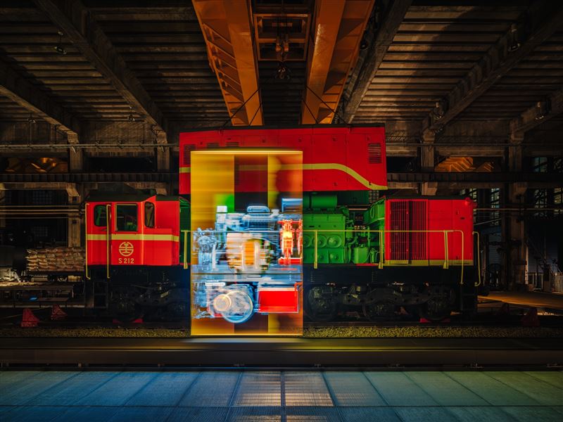 夜間燈光與展示影像映照S212號柴電機車,呈現車輛與工場展演結合的視覺效果。(圖/當若科技藝術提供)