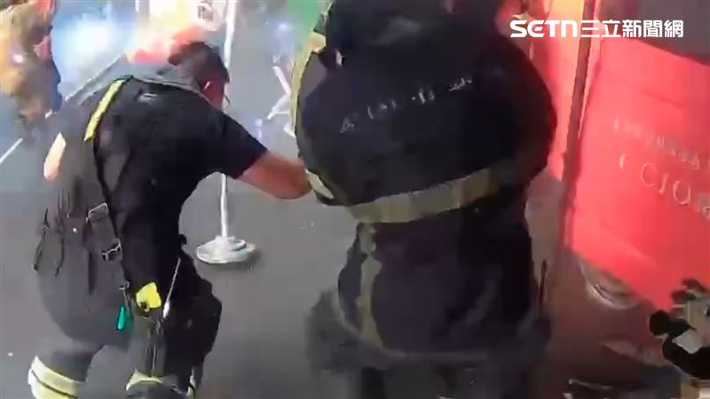 從曝光畫面仔細一看,打火弟兄與迎面炸開的火光之間,幾乎只隔著身上一層防護衣,令人捏把冷汗。(圖/翻攝畫面)