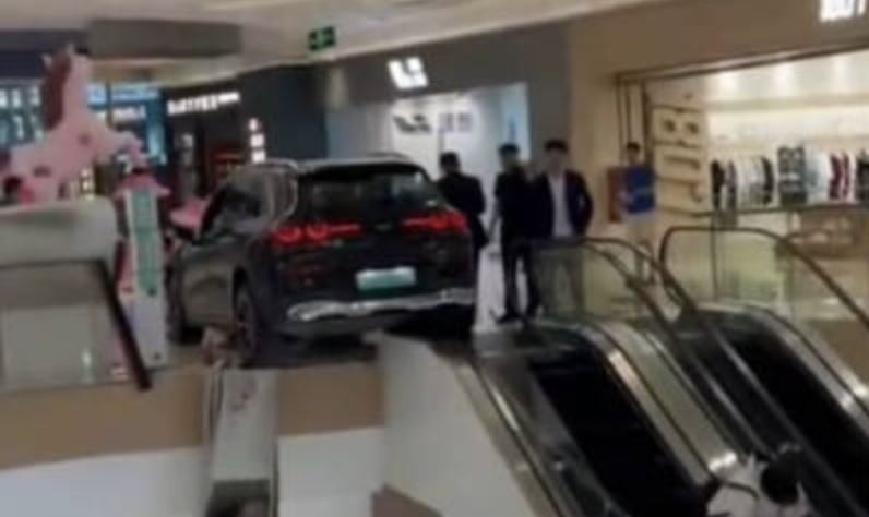 賓士展示車突然倒車暴衝,撞碎強化玻璃護欄險墜落。(圖/翻攝自微博)