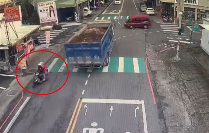 機車騎士雙載先一步左轉通過路口，差一點遭疾駛的大貨車追撞，心有餘悸停在路邊查看。(圖／翻攝畫面)