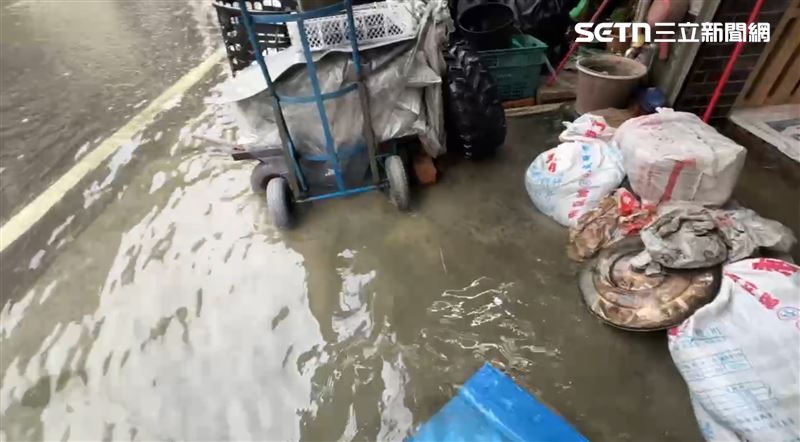 新園鄉居民堆沙包仍擋不住水淹入家門。(圖/記者朱俊傑攝影)