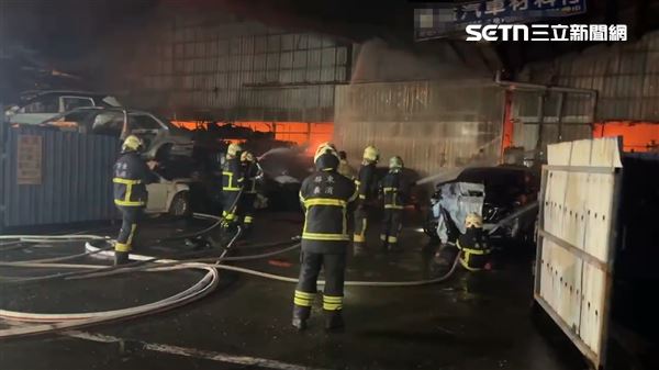 屏東縣萬丹鄉汽車回收廠發生火警,現場不斷傳出爆炸聲響,消防隊灌救中。(圖/翻攝畫面)