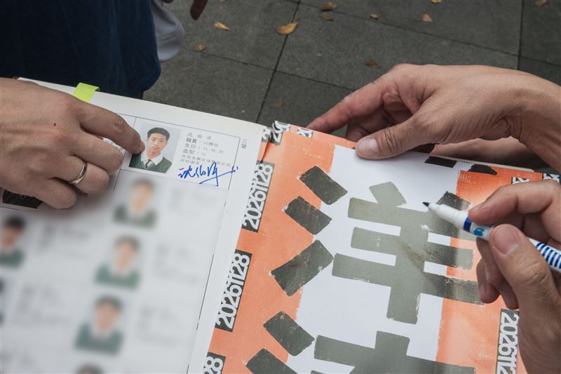 民進黨台北市長參選人沈伯洋今(30)日赴永春市場掃街拜票,一位民眾拿出復興國中畢業紀念冊要簽名,也意外曝光了沈伯洋國中的模樣。(圖/沈伯洋競辦提供)