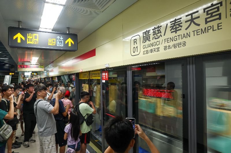 台北捷運信義線東延段廣慈/奉天宮站30日下午通車,首班列車進站吸引月台民眾拍攝記錄