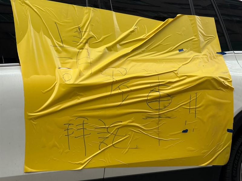 車身被貼上黃色塑膠膜,還留字「請移車」。(圖/翻攝畫面)