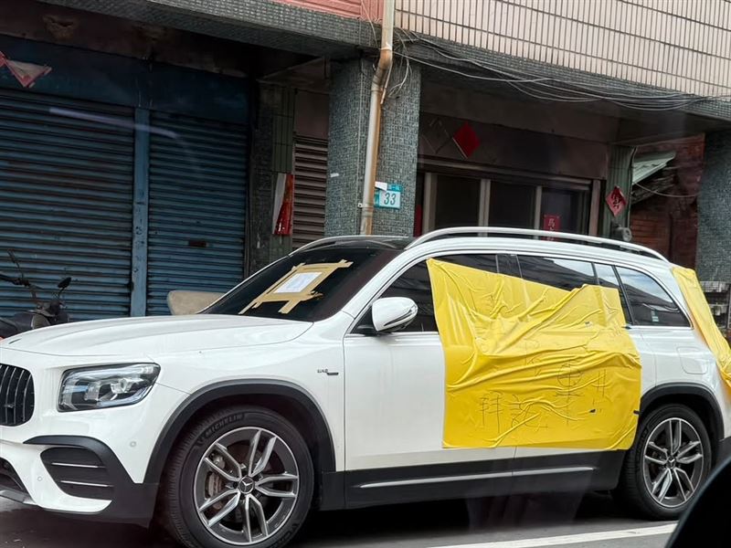 一名男子將賓士休旅車臨停在民宅前路邊白線上,要離開時發現車身被貼上黃色塑膠膜。(圖/翻攝畫面)