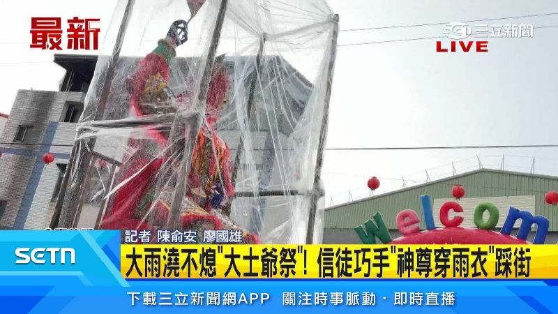 信徒為大士爺圍上透明雨衣