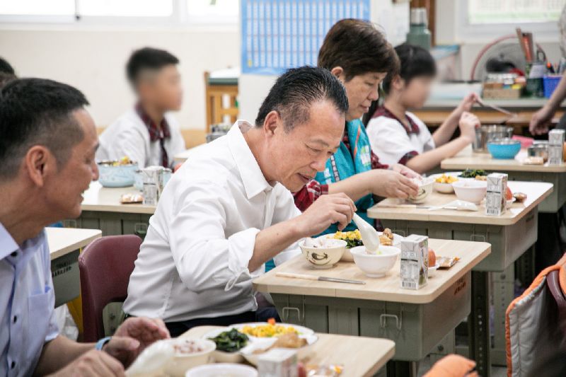 嘉義縣自115學年度起,全面推動所屬公立高中、國中及國小學生免費營養午餐政策,縣長翁章梁(左2)31日到太保市祥和國小視察營養午餐供應情形,並與小朋友共進午餐