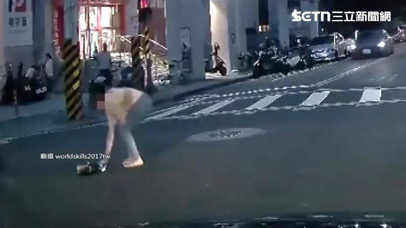 女子從車上跳下來整個人翻滾了一圈才停下,她默默起身撿起地上的包包走到人行道上。(圖/翻攝自Threads @worldskills2017tw)