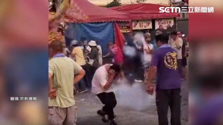 路過民眾被鞭炮洗禮,嚇得彎腰抱頭。(圖/翻攝自宗教爆報)