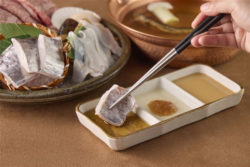 白帶魚放入飛魚旨湯中輕涮,蘸取特製「魷魚醬油」,增添醬香與鮮味層次。(圖/品牌業者提供)