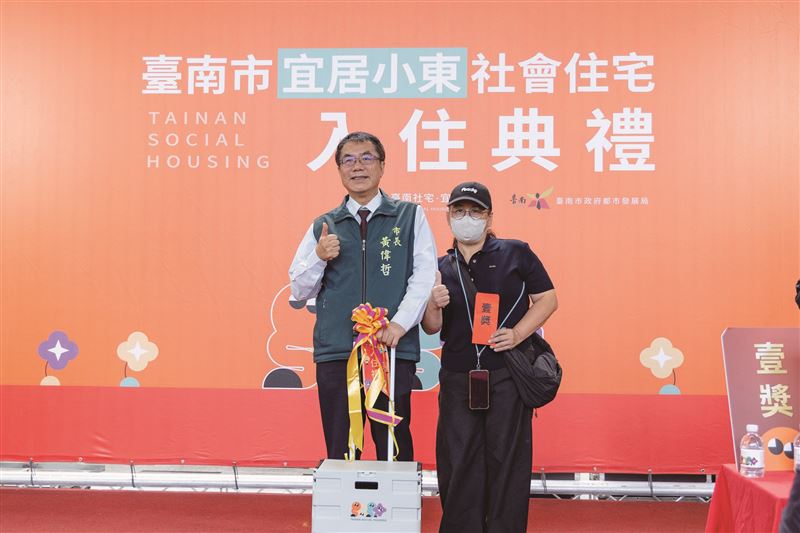 宜居小東熱鬧舉辦入住典禮與抽獎活動，由黃偉哲市長抽出一獎得主，並致贈入住禮「折疊推車」，象徵市府對每位住戶幸福生活的祝福與支持。（圖／臺南市政府都市發展局提供）