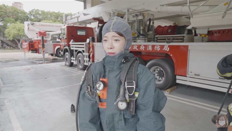 李多慧換上重達約20公斤的消防衣與氣瓶裝備,挑戰負重爬上無電梯的5樓進行佈線射水訓練。(圖/翻攝自李多慧YouTube)