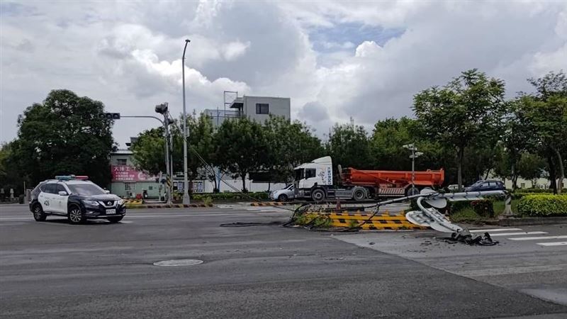 李男駕駛曳引車行經路口時,因防塵網未降下扯斷號誌燈桿。(圖/翻攝畫面)