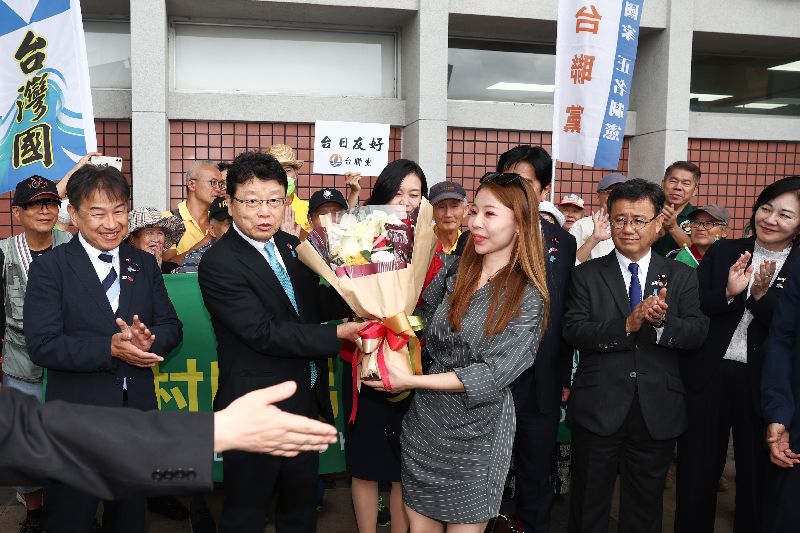 日本跨黨派國會議議員訪問團8日抵達台北松山機場,台灣國理事長陳峻涵率團接機並安排歌手鐘綺(前左3)獻花歡迎,日本保守黨參議員北村晴男(前左2)代表接受