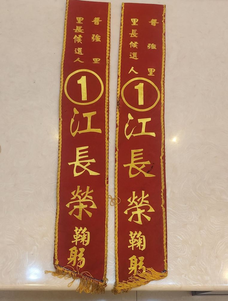 江長榮每次選舉的競選揹帶都是同一條,因為同額競選,每次都是「1號」。(圖/翻攝自臉書)