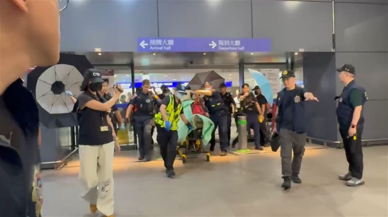 航警開傘將嫌犯送上救護車。(圖/記者石明啟攝影)