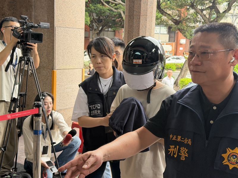 易姓女槍手被押解進警局時緊張地踉蹌險跌倒。(圖/翻攝畫面)