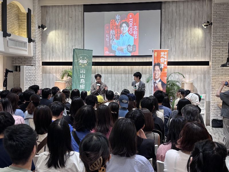 投入台北市長選戰的民進黨立委沈伯洋(講台左方)13日晚間在東京舉辦座談會。主辦單位表示,這場活動吸引約100多人參加,報名資訊上線約1小時便額滿