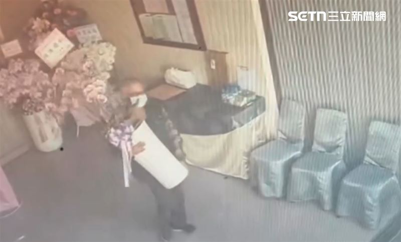 靈堂四下無人,一名白髮男子熟門熟路相中一盆價值6000元的陶瓷蘭花直接搬走。(圖/「陽光禮儀.生前契約」提供)