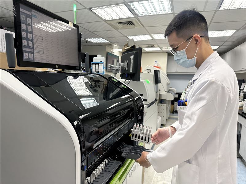 檢驗人員操作自動化血液檢驗設備,確認腫瘤標誌指數。(圖/豐原醫院提供)