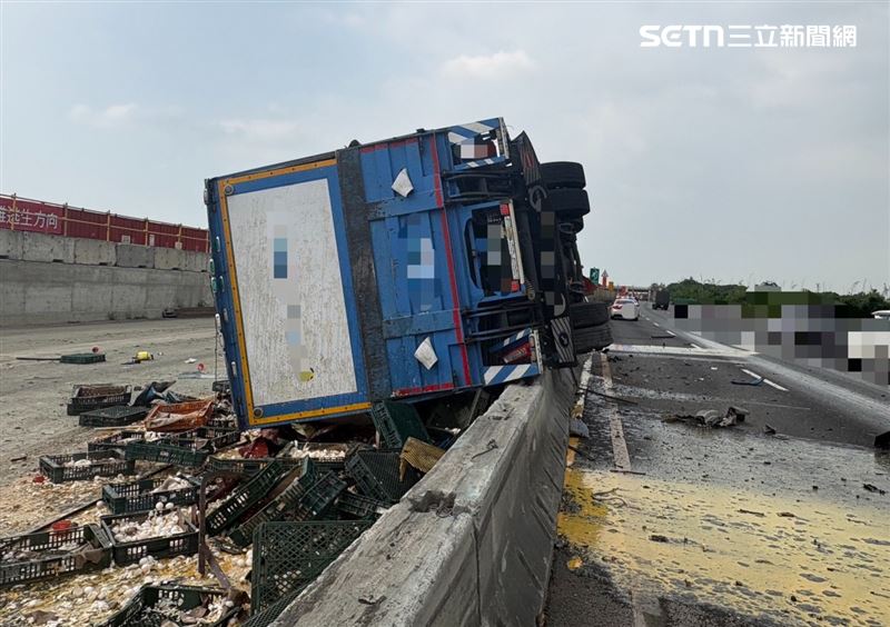 國1驚傳爆胎翻車!大貨車撞爛「內側翻覆」灑蛋液,駕駛OHCA送醫。(圖/翻攝畫面)