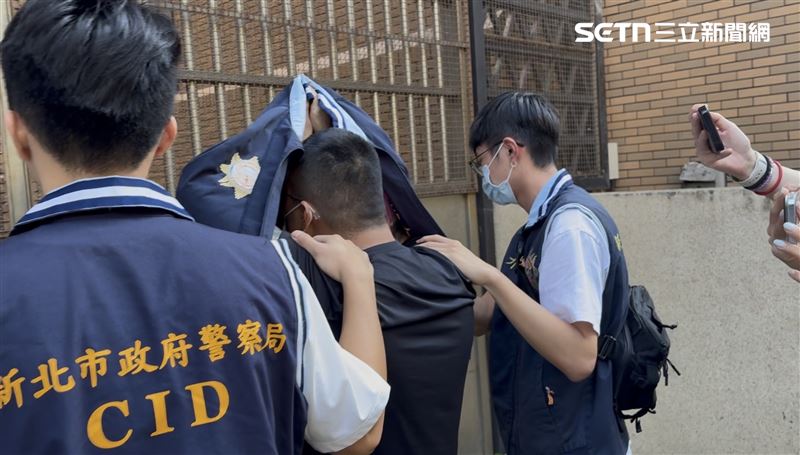 檢警在台南逮獲伍姓男子,移送北檢複訊時,伍男以背心遮臉。(圖/記者楊佩琪攝)