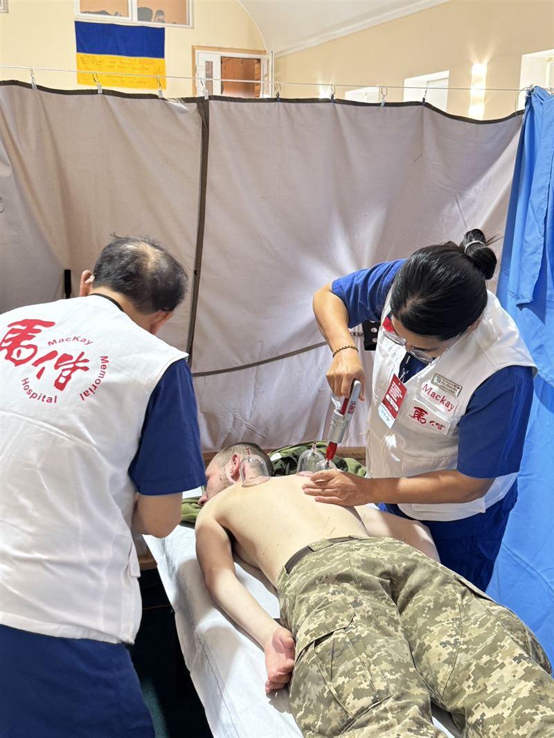 陳光偉主任(圖左)及吳佩珊醫師於茲維亞赫爾（Zviahel）教堂為軍人做傳統醫學治療。（圖／翻攝自馬偕醫院官網）