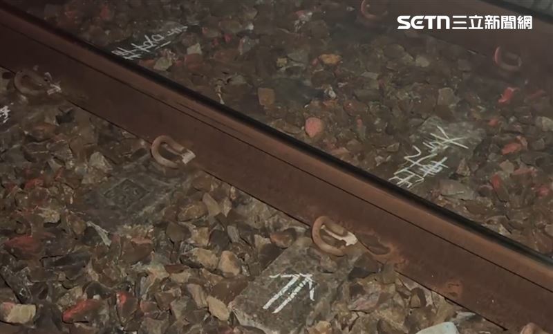 台鐵人員持手電筒摸黑繞行車廂，沿著鐵軌一寸一寸仔細巡查，終於找到出軌位置並立即做記號。（圖／翻攝畫面）