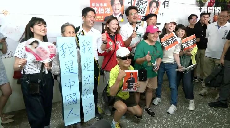 民眾拿「我是中國人,我選沈伯洋」標語合影。(圖/翻攝畫面)