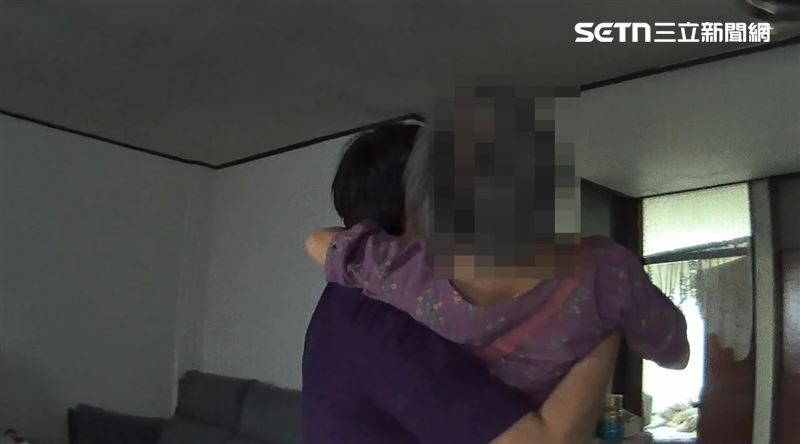 婦人進屋後再度因雙腿無力,差點摔倒,員警決定採公主抱送婦人進臥室休息。(圖/翻攝畫面)