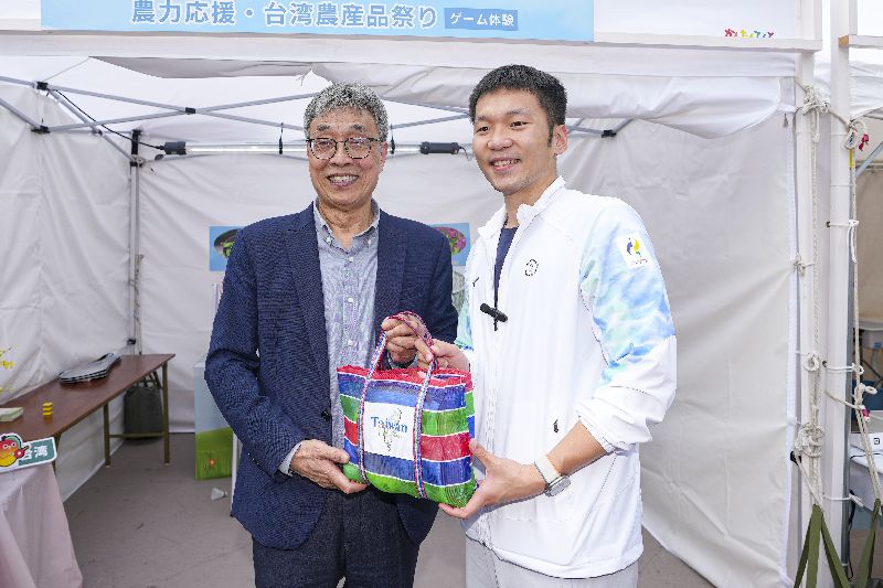 農業部亞運期間在日本名古屋舉辦「台灣農產品特展」,運動部長李洋(右)、農業部長陳駿季(左)出席推廣,2人一同拿著充滿台灣特色的茄芷袋合影