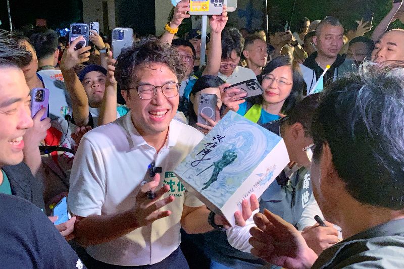 民進黨台北市長參選人沈伯洋(中)20日晚間赴桃園市中壢夜市,現場擠滿眾多支持者排隊等候簽名合照,甚至從人行道延伸到馬路上。(圖/中央社)