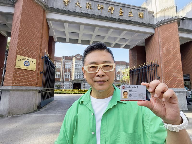 朱正生日前拿到師範大學美術研究所的學生證，開心在校門口拍照留念。（圖／朱正生提供）