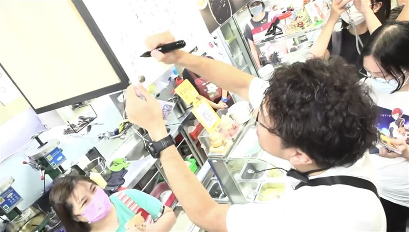 沈伯洋延三夜市掃街再現洋流,也在店家內簽下名字。(圖/翻攝畫面)