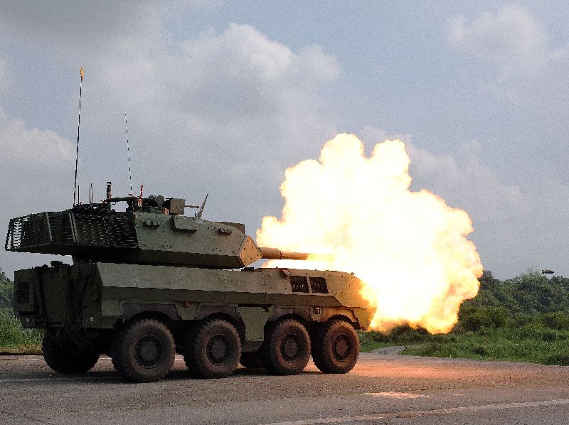 國防部軍備局23日在陸軍南測中心進行105公厘輪型戰車量產車型性能展示。圖為戰車砲對靜態敵戰車靶發射高爆戰防曳光彈。(圖/中央社)