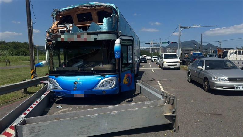 簡姓司機駕駛遊覽車,疑因不熟悉路況,誤駛入限高路段,造成遊覽車車頭上半部「被削掉」,還波及路過的趙姓女騎士。(圖/翻攝畫面)