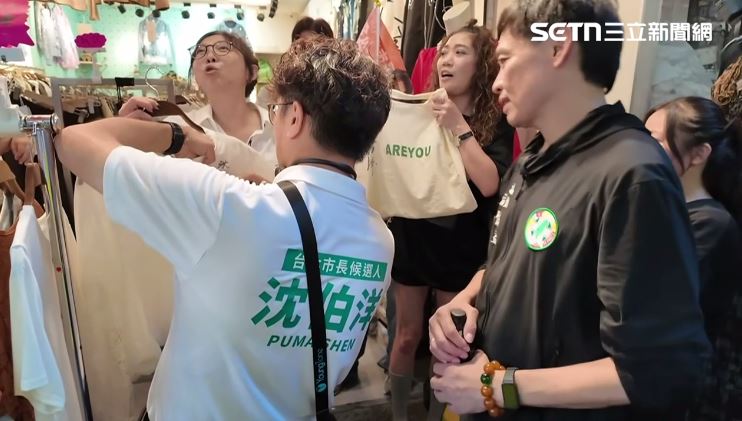 沈伯洋五分埔掃街受店家與民眾歡迎,在衣服上簽名,民眾更大喊「你的市長蘇巧慧、我的市長沈伯洋」。(圖/翻攝畫面)