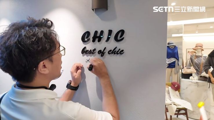 沈伯洋五分埔掃街受店家與民眾歡迎,更在店家牆壁上簽名。(圖/翻攝畫面)